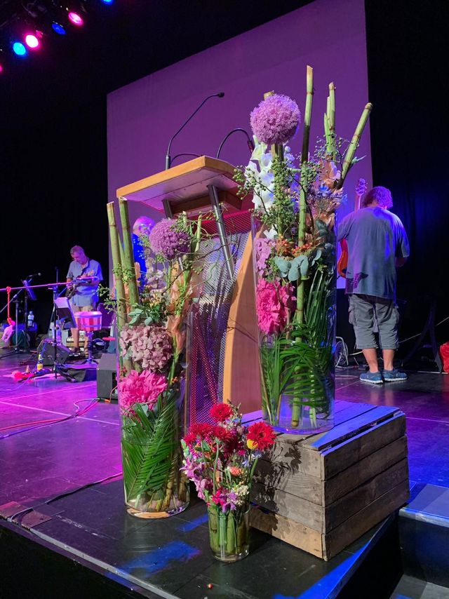 Bühnendekoration bühnendeko blumen am Rednerpult veranstaltungsfloristik business tagung seminar festival
